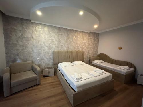 a hotel room with two beds and a chair at Karo Hotel in K'obulet'i
