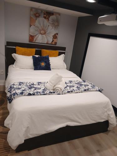 a bedroom with a large bed with blue and white sheets at Furnished calm basement studio apartment in Mississauga