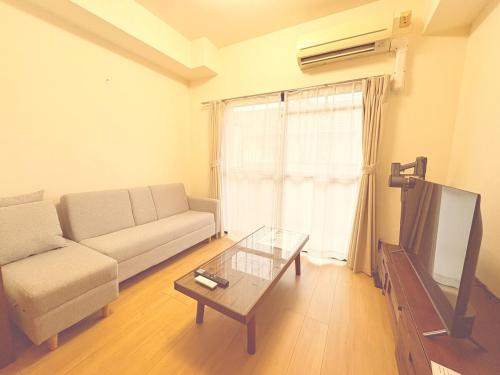 a living room with a couch and a table at matsuokabase in Kitakyushu