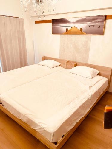 two beds in a bedroom with white sheets at matsuokabase in Kitakyushu