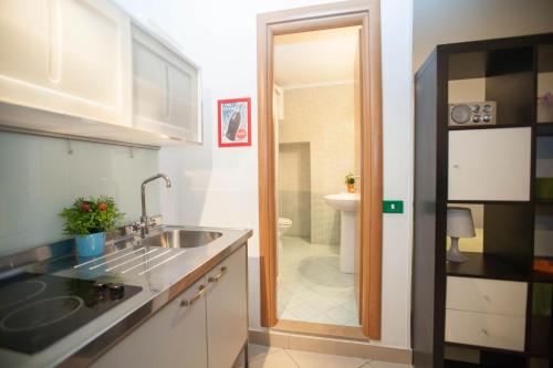 eine kleine Küche mit einem Waschbecken und ein Badezimmer in der Unterkunft Serra Casa Vacanza a Piazza del Plebiscito in Neapel