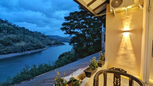 a balcony with a view of a river at night at Blue Waters Edge - Kandy in Kande