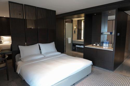 a bedroom with a large white bed and a bathroom at Eastern House Xi'an in Xi'an