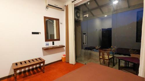 a living room with a mirror and a table and chair at Blue Waters Edge - Kandy in Kande