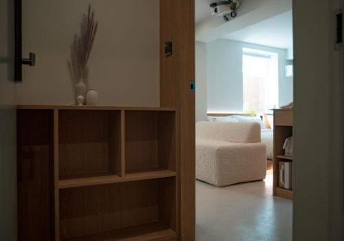 a living room with a book shelf and a chair at Yeobaek Hotel in Incheon