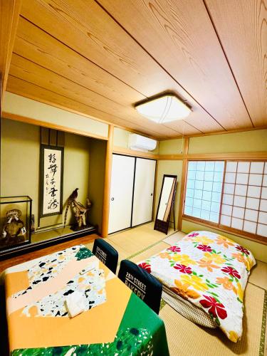 a room with a bed and a table in it at 麗静亭 in Koga