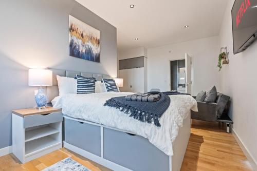 a bedroom with a large bed and a desk at Leeds Elegant Central Flat - Sleeps 8 - Highrise View City Centre in Central Station