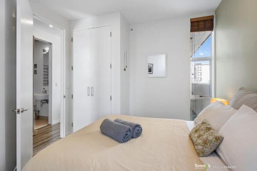 a bedroom with a bed with a blue towel on it at Sunny and Central Wellington Apartment in Wellington