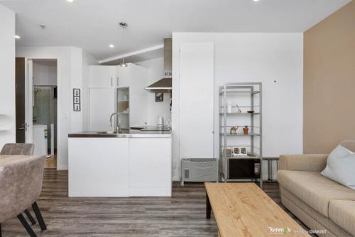 a living room with a couch and a kitchen at Sunny and Central Wellington Apartment in Wellington