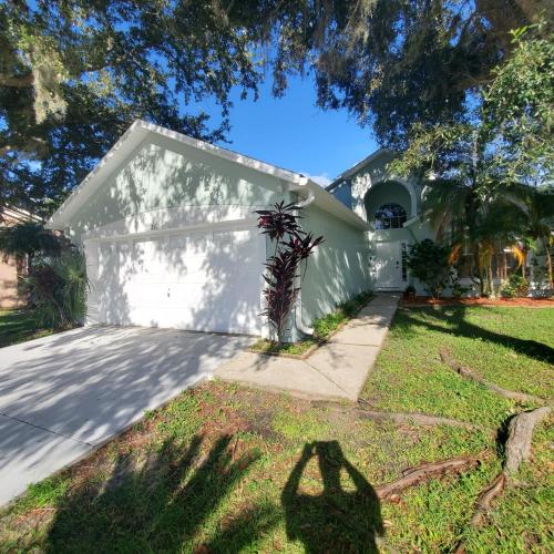 a person standing in front of a white house at Family Getaway by Disney! in Kissimmee