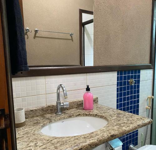 a bathroom sink with a pink soap bottle on it at Casa em Bonito in Bonito