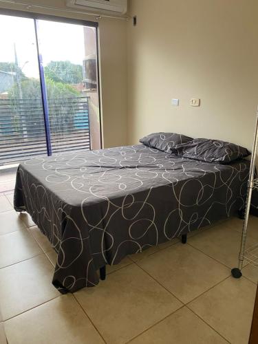 a bed in a room with a large window at Casa em Bonito in Bonito