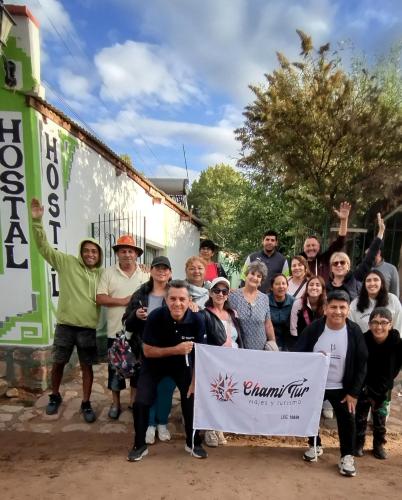 a group of people posing for a picture with a sign at Hostal Bella Esperanza in Humahuaca