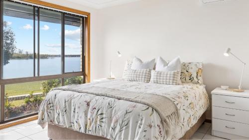une chambre avec un lit et une grande fenêtre dans l'établissement Peninsula Court Unit 10, à Yamba