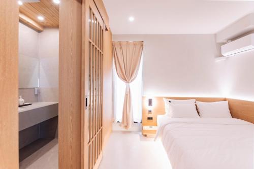 a bedroom with a large white bed and a window at Yeobaek Hotel in Incheon