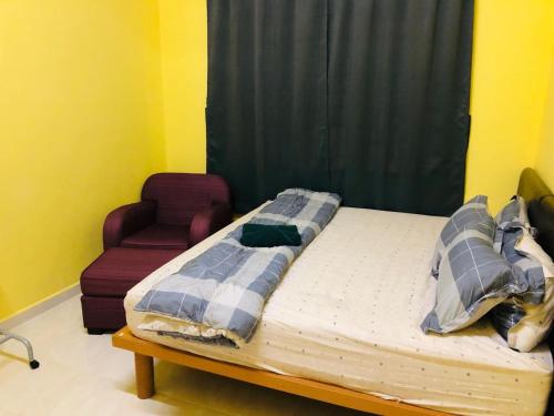 a bed in a room with a couch and a chair at Homestay Salam Marang Terengganu in Marang