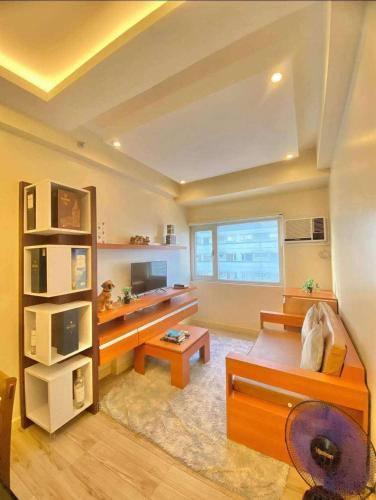 un salon avec un canapé et une télévision dans l'établissement Relax in Style Walk into City, Roxas Market with Pool, à Davao