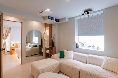 a living room with a couch and a mirror at Yeobaek Hotel in Incheon