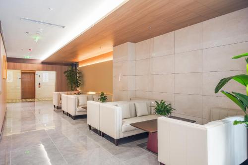 a waiting room with white couches and plants at 北京刘家窑地铁站万信至格酒店 in Beijing