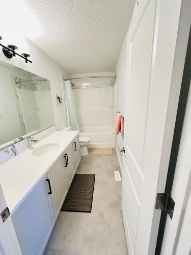 a bathroom with a sink and a mirror at Relax at The Hills at Ellerslie in Edmonton