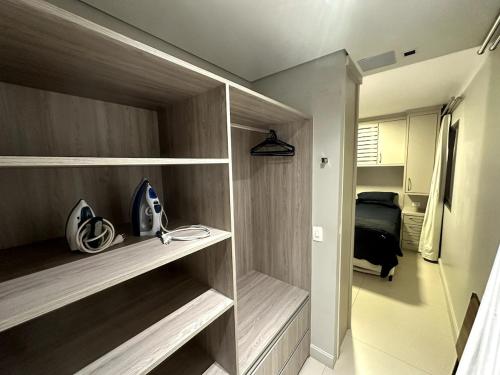 a walk in closet with wooden shelves in a room at Lindo apartamento em São Paulo in Sao Paulo