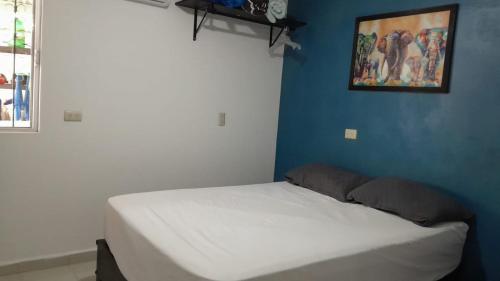 a bed in a room with a blue wall at CASA con 2 habitaciones, Cocina,comedor y baño privados in Candelaria