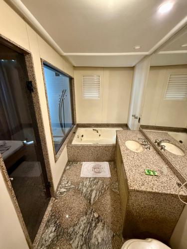 a bathroom with two sinks and a tub at Hotel Sheik (Adults Only) in Rio de Janeiro