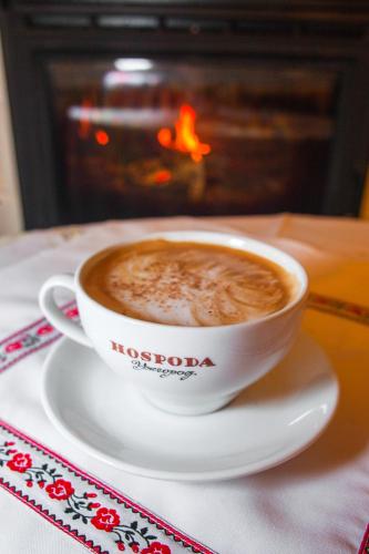 a cup of coffee sitting on a plate in front of a fireplace at Кімнати в центрі in Uzhhorod