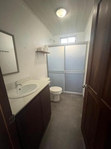 a bathroom with a sink and a toilet at La Casa Pina Pacifica near La Fortuna in San Ramón
