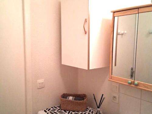 La salle de bains est pourvue d'un miroir, d'un lavabo et d'une armoire. dans l'établissement Super Besse: Appartement 6 pers. lumineux avec balcon et cuisine équipée - FR-1-814-144, à Besse-et-Saint-Anastaise