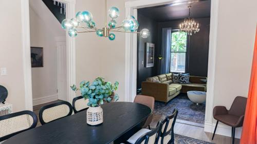 a dining room with a table and a living room at Red Brick Row by StayLage in Saint Louis