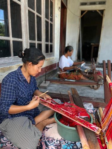 a woman is working on a pair of scissors at PANORAMA BUNGALOWs in Tetebatu