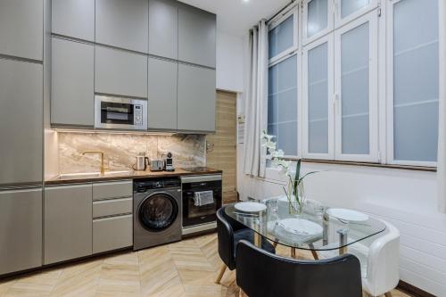 - une cuisine avec une table en verre et un évier dans l'établissement Luxury Loft Saint-Michel, à Paris