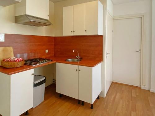 a kitchen with white cabinets and a sink at Skyscraper apartment on the highest point with beautiful view in Bergen aan Zee