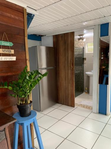 a kitchen with a blue stool and a refrigerator at Bela Vista - Casa Beira Mar in Paranaguá