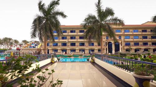 a hotel with a swimming pool in front of a building at Green Desert in Madīnat as Sādāt