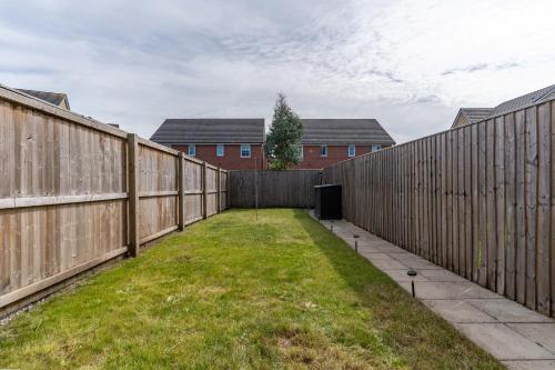 a backyard with a fence and a grass yard at Walk to Liverpool Airport - Luxury Stay with EV Charge - Fast WiFi in Liverpool