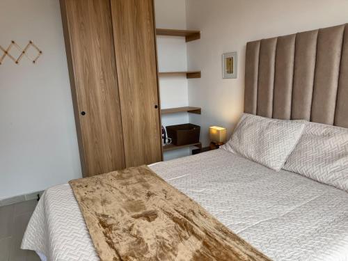 a bedroom with a large bed with a wooden headboard at Apartamento en el parque principal con vista a la represa in Guatapé