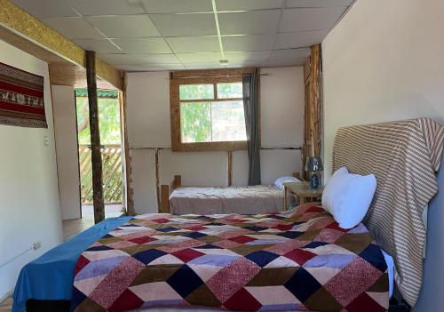 a bedroom with a bed with a colorful quilt at Hostel "La Casa de Ricky" in Caraz