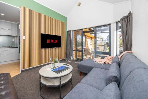a living room with a couch and a tv at Great Short-Mid Term Stay! River Views & Games Room in Hamilton