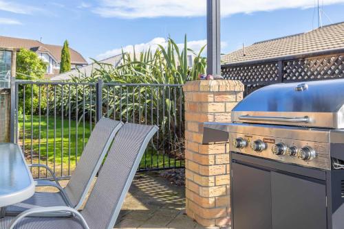a grill with two chairs and a table and a table and a grill at Great Short-Mid Term Stay! River Views & Games Room in Hamilton