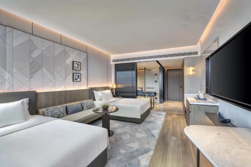 a hotel room with two beds and a flat screen tv at Crowne Plaza Rugao in Nantong