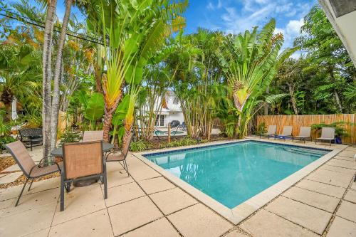 a swimming pool in a yard with chairs and trees at Inn On The Drive in Fort Lauderdale