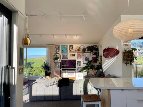 a living room with a couch and a table at Elevated architectural home with stunning sea views in Dunedin