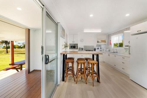 une cuisine avec un bar et des tabourets. dans l'établissement Cottage 1 Cape Keppel Beach, à Curtis Island