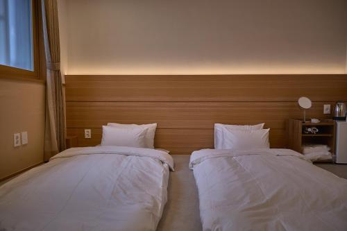 two beds sitting next to each other in a bedroom at Stay Libera in Gangneung