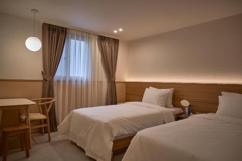 a hotel room with two beds and a window at Stay Libera in Gangneung