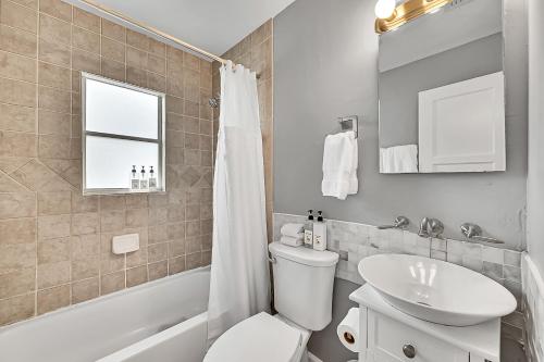 a bathroom with a white toilet and a sink at Inn On The Drive in Fort Lauderdale