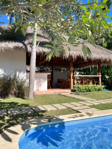 a resort with a swimming pool and a hut at Villa Mila - Gili Air in Gili Air