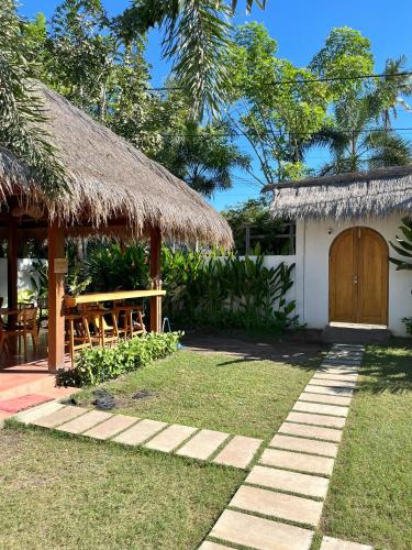 a small hut with a wooden door and a grass roof at Villa Mila - Gili Air in Gili Air